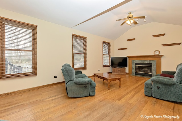 living room featuring ceiling fan, light hardwood / wood-style floors, and vaulted ceiling