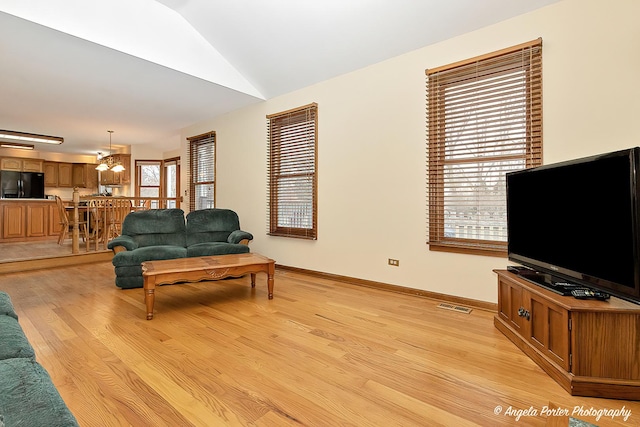 living room with vaulted ceiling and light hardwood / wood-style flooring