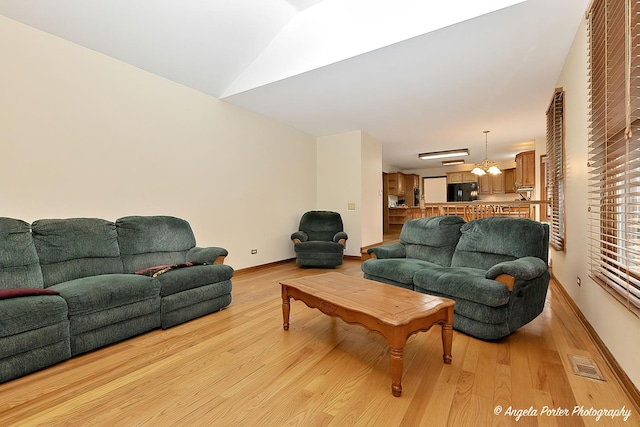 living room with light wood-type flooring and lofted ceiling