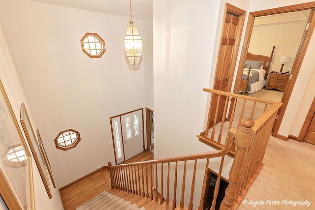 stairs with hardwood / wood-style flooring and a high ceiling