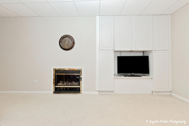 interior details featuring a fireplace, carpet, and a drop ceiling