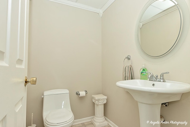 bathroom with sink, toilet, and ornamental molding