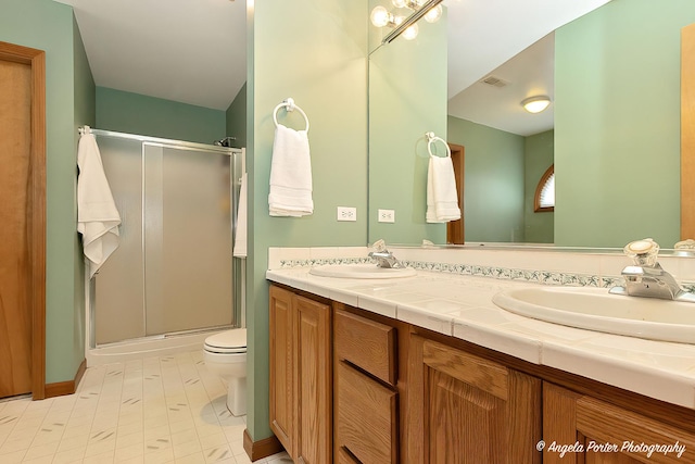 bathroom featuring vanity, toilet, and an enclosed shower