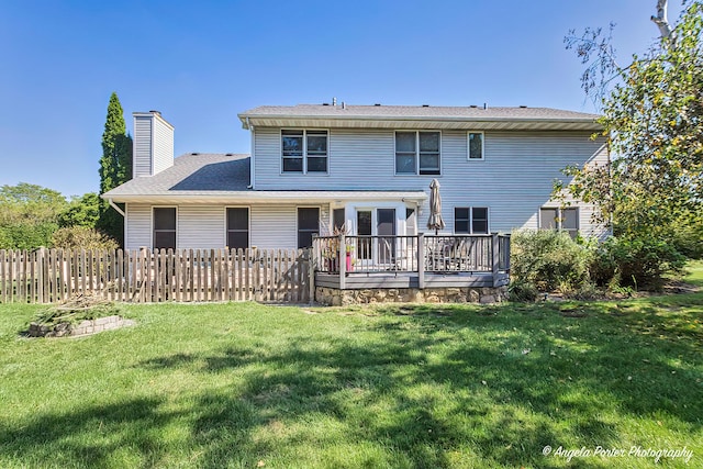 rear view of property with a deck and a lawn