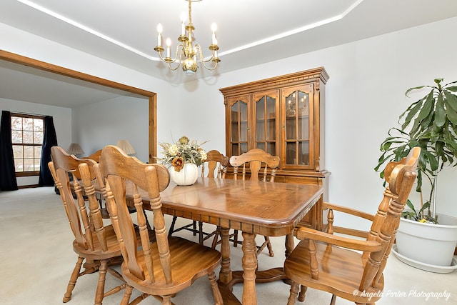 carpeted dining space featuring a chandelier