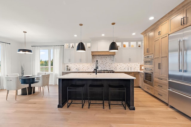 11060 Lizmore Ln Unit 27B, Orland Park, IL 60467 - kitchen featuring appliances with stainless steel finishes, backsplash, light wood finished floors, a breakfast bar, and recessed lighting