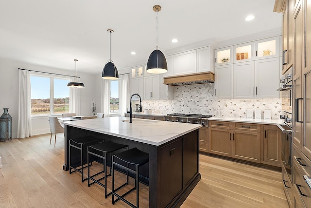 11060 Lizmore Ln Unit 27B, Orland Park, IL 60467 - kitchen with appliances with stainless steel finishes, a sink, decorative backsplash, light stone counters, and a breakfast bar