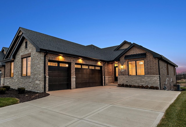 11060 Lizmore Ln Unit 27B, Orland Park, IL 60467 - view of front of property featuring stone siding, a garage, driveway, and a shingled roof