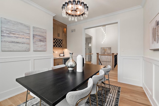 11060 Lizmore Ln Unit 27B, Orland Park, IL 60467 - dining room with a chandelier, ornamental molding, light wood-type flooring, a decorative wall, and a wainscoted wall