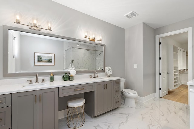 bathroom with vanity, toilet, and a shower with door