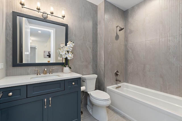 full bathroom featuring vanity, tiled shower / bath, tile patterned flooring, toilet, and tile walls