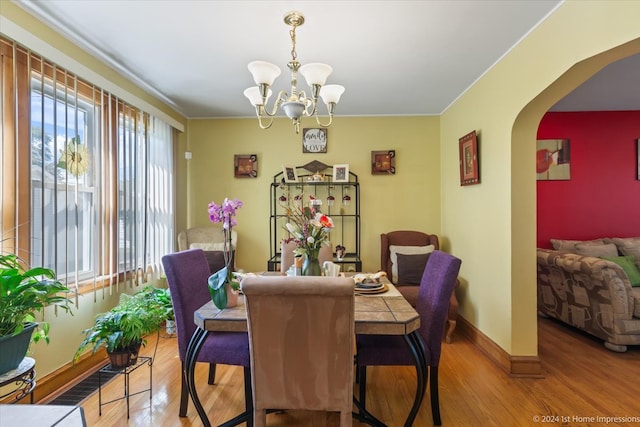 dining space featuring an inviting chandelier, crown molding, and hardwood / wood-style floors