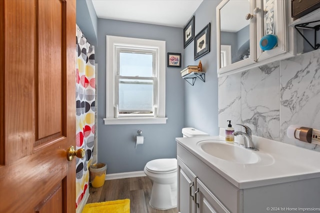 bathroom with vanity, toilet, hardwood / wood-style flooring, and decorative backsplash