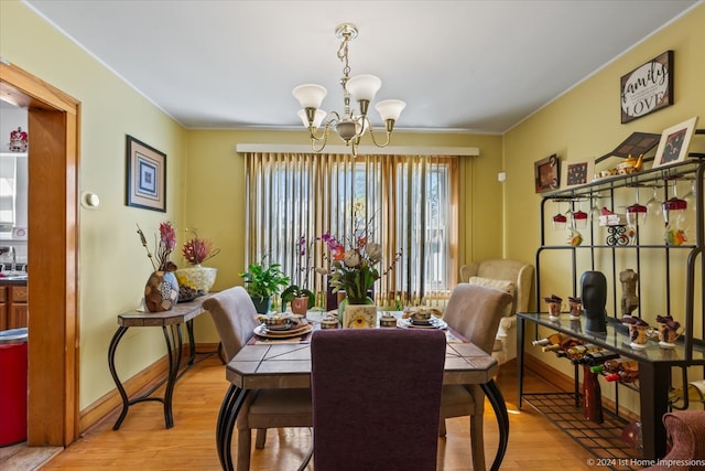 dining space featuring an inviting chandelier, light wood-type flooring, and ornamental molding