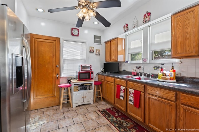 kitchen featuring stainless steel fridge, backsplash, sink, and ceiling fan