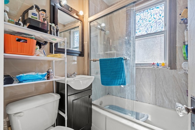 full bathroom featuring shower / bath combination with glass door, vanity, and toilet