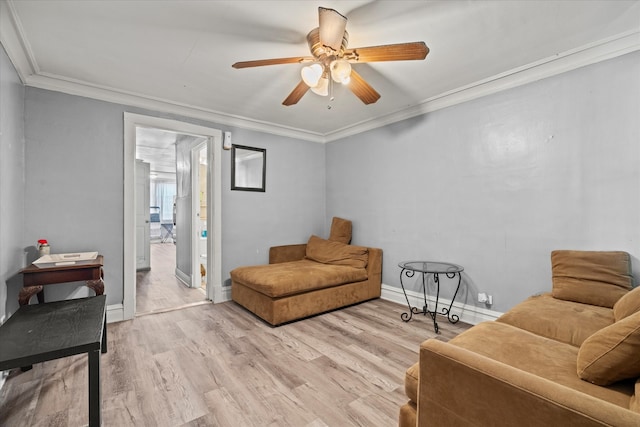 living room with light hardwood / wood-style floors, ornamental molding, and ceiling fan