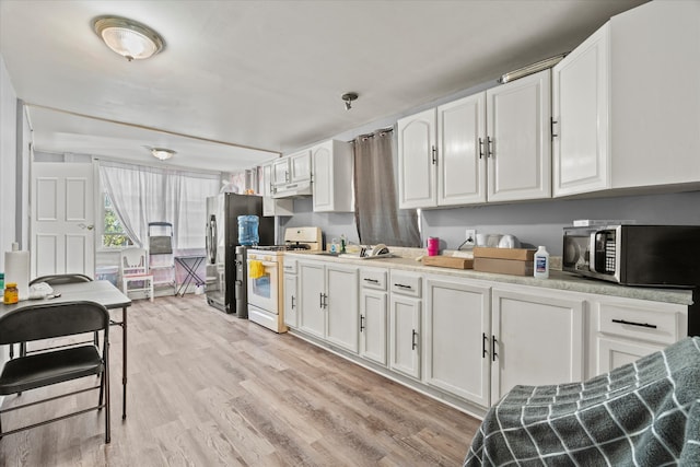 kitchen with light hardwood / wood-style floors, stainless steel appliances, and white cabinets