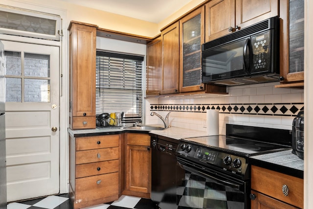 kitchen with backsplash, sink, a healthy amount of sunlight, and black appliances