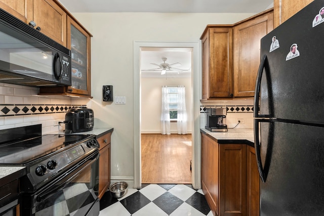 kitchen with black appliances, ceiling fan, hardwood / wood-style floors, and backsplash