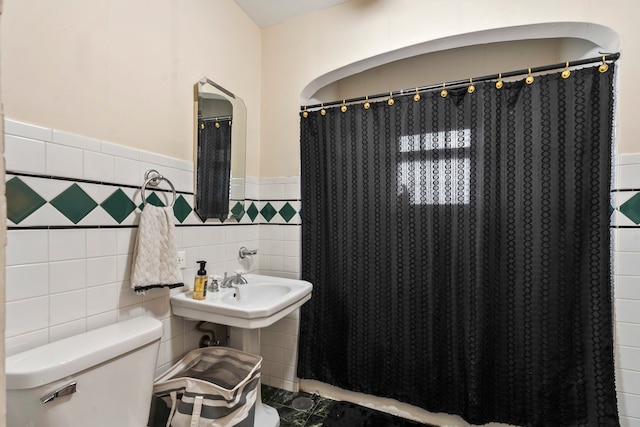 bathroom with tile walls and toilet