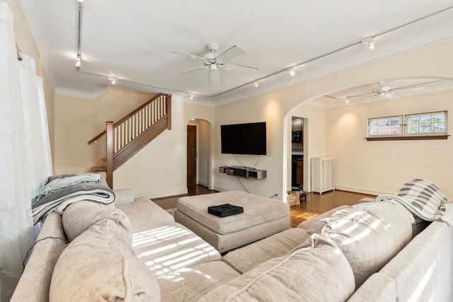 living room featuring ceiling fan, light wood-type flooring, ornamental molding, and rail lighting