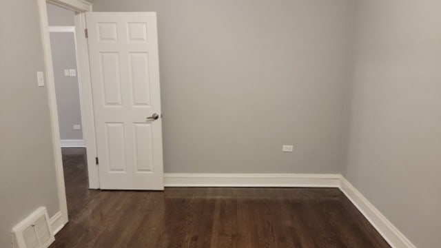 unfurnished room with dark hardwood / wood-style flooring