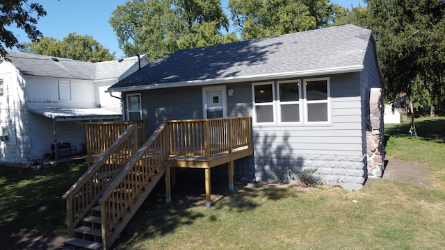 rear view of property featuring a wooden deck and a yard