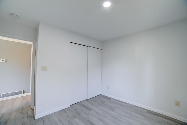 unfurnished bedroom featuring a closet and light hardwood / wood-style flooring