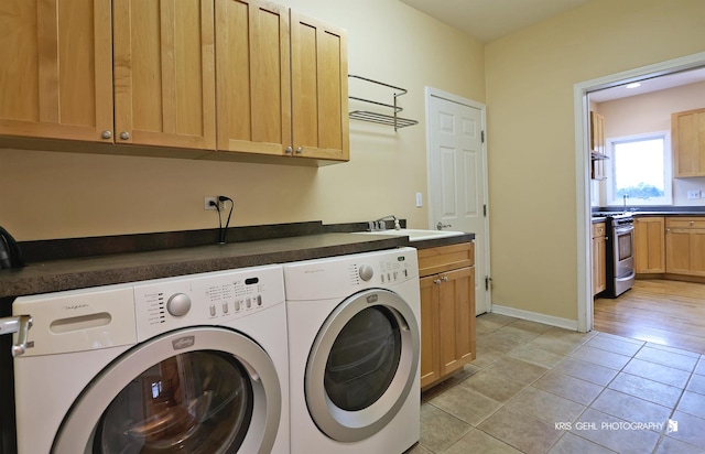 laundry area featuring washer and dryer, cabinets, light tile patterned floors, and sink