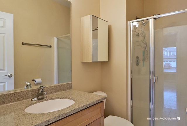 bathroom with vanity, toilet, and an enclosed shower