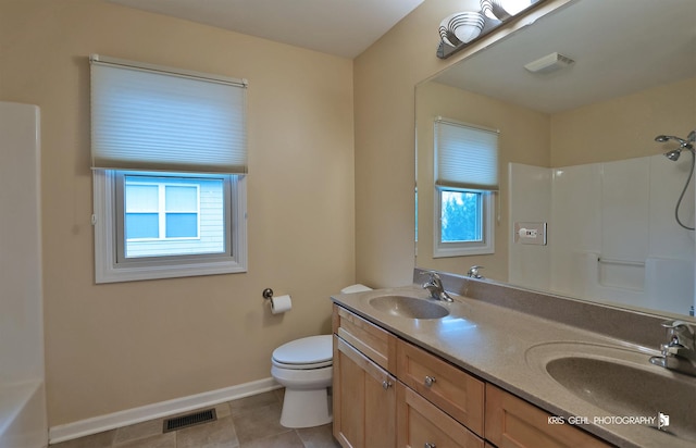 bathroom featuring tile patterned flooring, vanity, toilet, and a shower