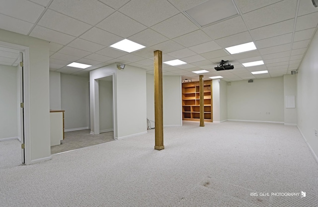 basement with a drop ceiling and light colored carpet