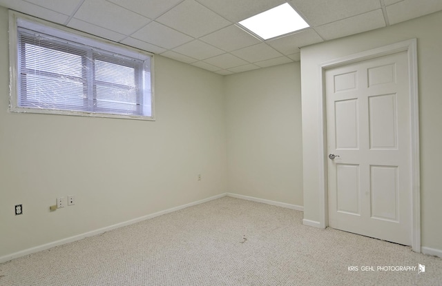 empty room with a paneled ceiling and light colored carpet