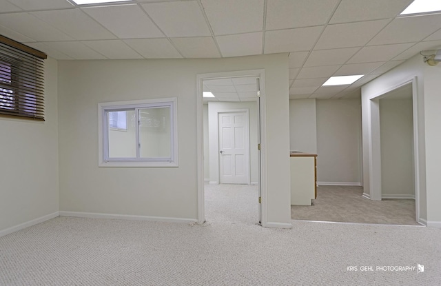 carpeted empty room with a paneled ceiling