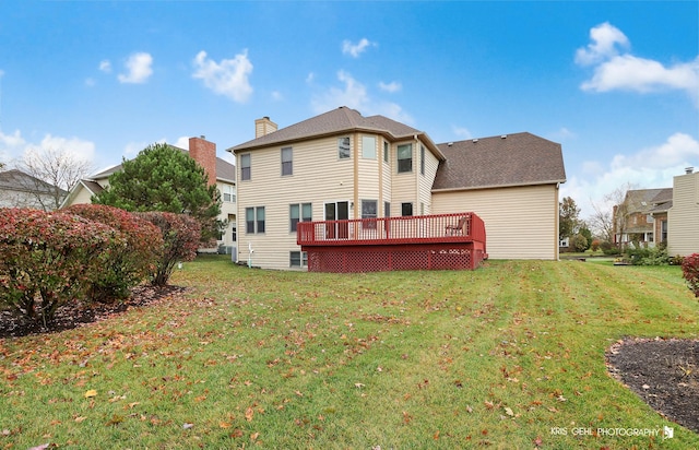 back of property with a deck and a yard