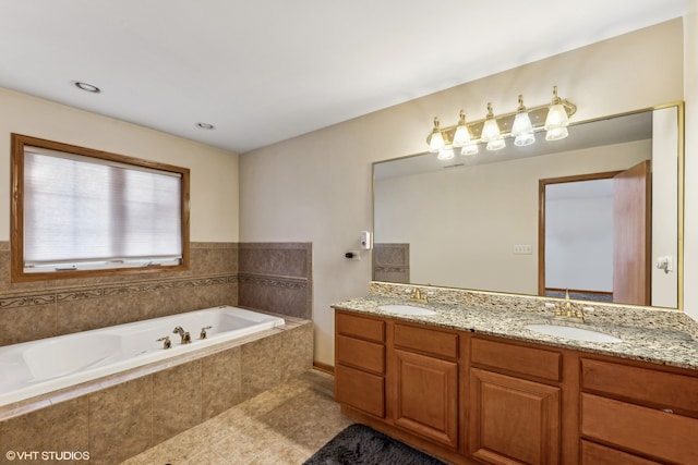 bathroom with tiled bath and vanity