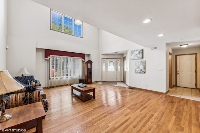 living room featuring light hardwood / wood-style floors and a towering ceiling