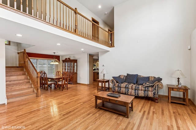 living room featuring a high ceiling and light wood-type flooring