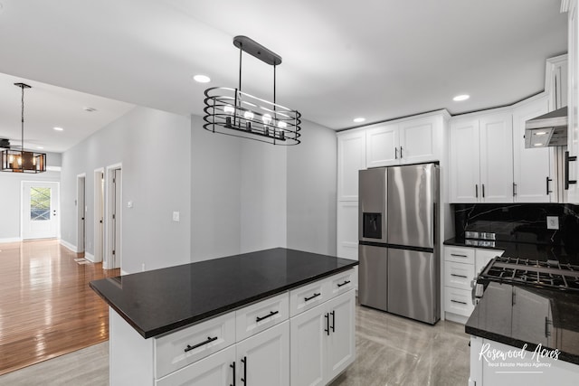 kitchen with ventilation hood, white cabinets, a kitchen island, and stainless steel fridge