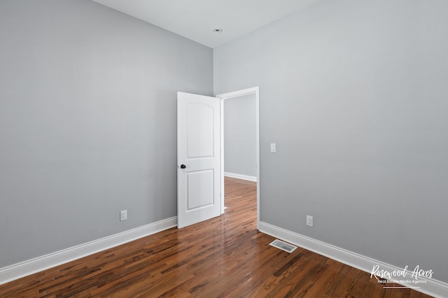 unfurnished room featuring dark wood-type flooring