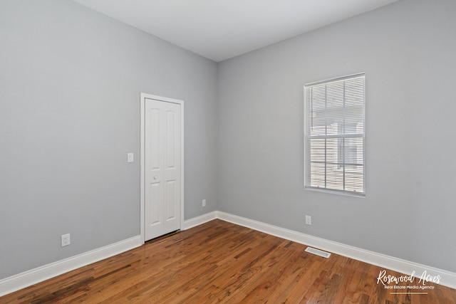 unfurnished room with wood-type flooring