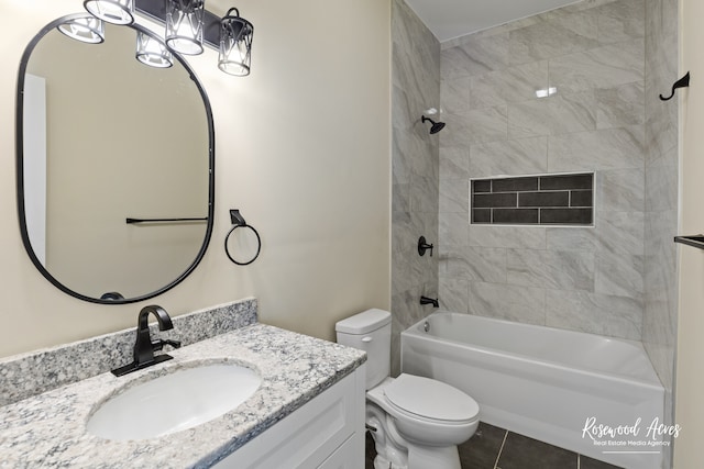 full bathroom featuring tile patterned floors, vanity, toilet, and tiled shower / bath combo