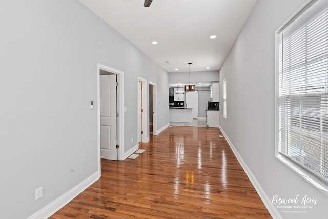 hall with an inviting chandelier, dark hardwood / wood-style flooring, and a wealth of natural light