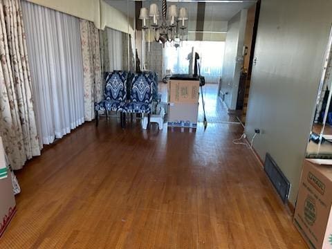 dining space with wood-type flooring and a notable chandelier