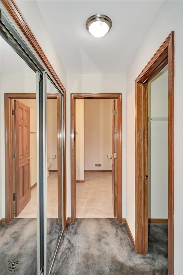 hallway featuring light colored carpet