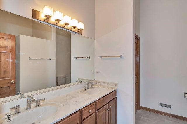 bathroom featuring toilet, vanity, and tile patterned floors