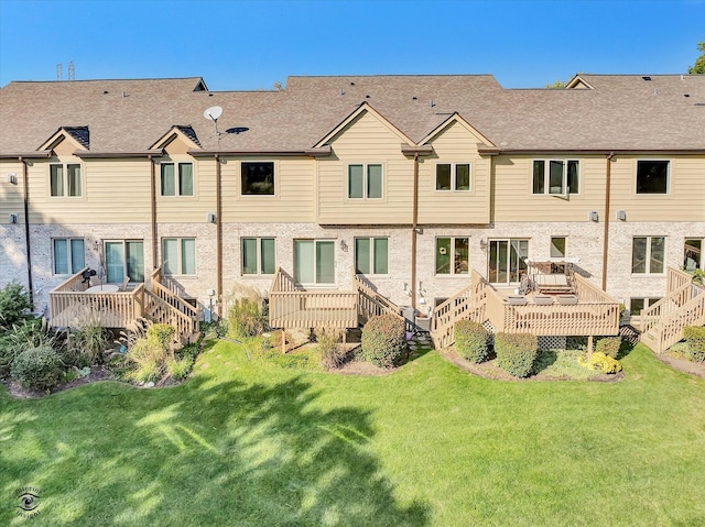 rear view of house featuring a yard and a deck