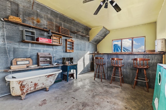 bar with ceiling fan and concrete flooring