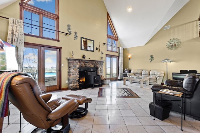 living room with high vaulted ceiling, light tile patterned flooring, and a healthy amount of sunlight